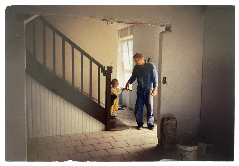 Flavie enfant avec son père en bleu de travail, dans la ferme familiale en travaux